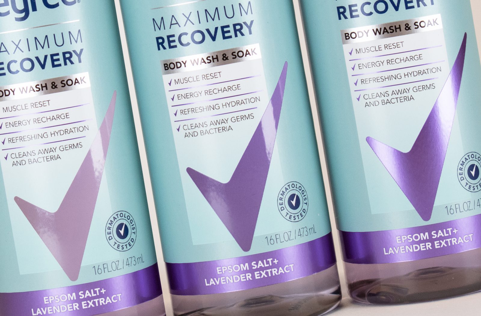 Photograph of three comps developed for a product line extension for Degree Maximum Recovery Body Wash, featuring metallic effects and a reimagined use of the brandmark.