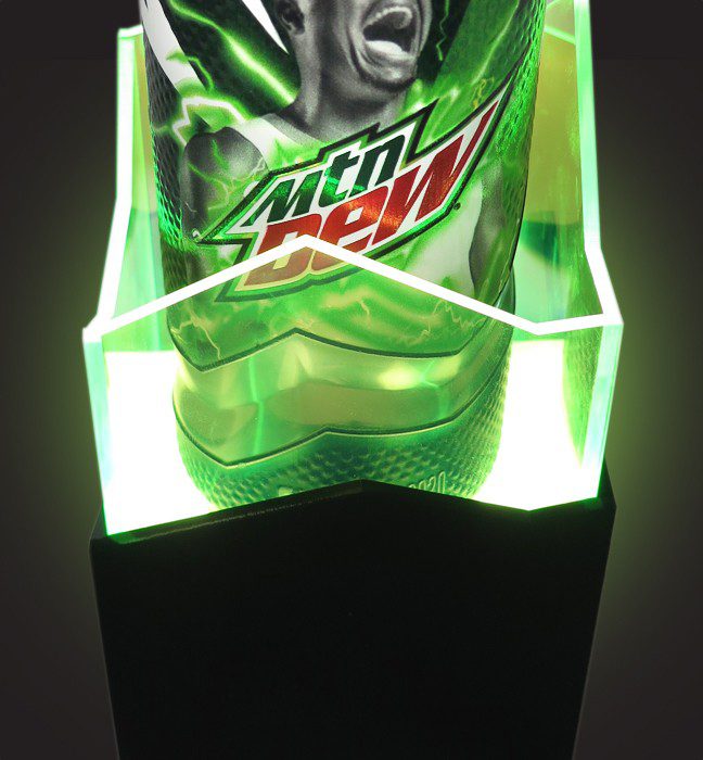 Close-up shot of an influencer unboxing experience for the Mountain Dew Basketball limited edition cans featuring NBA All-Stars, showcasing motion sensor LED lights creating a neon green glow.