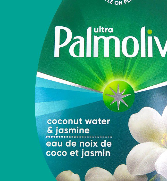 Close up photograph of a bottle of coconut water & jasmine palmolive dish soap, featuring a cold foil print technique used to create sales samples by a product packaging printing agency.