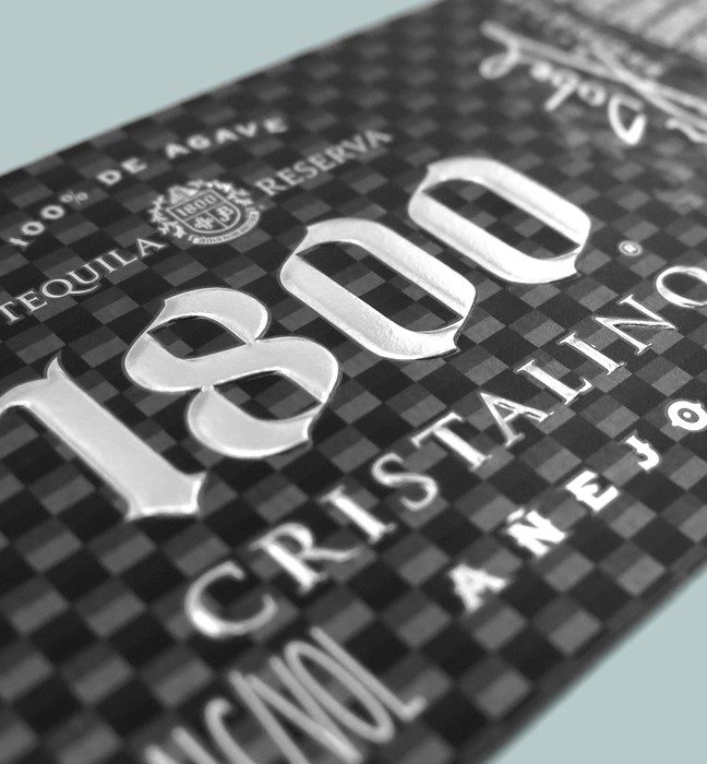 Close up photograph of a Proximo Spirits 1800 Cristalino Tequila label, showcasing production expertise and prototyping capabilities, created by a by a cpg packaging print and design agency.