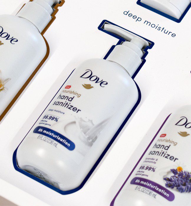 Close-up shot of the inside of an unboxing experience sales kit promoting skin moisturizing Dove hand sanitizer.