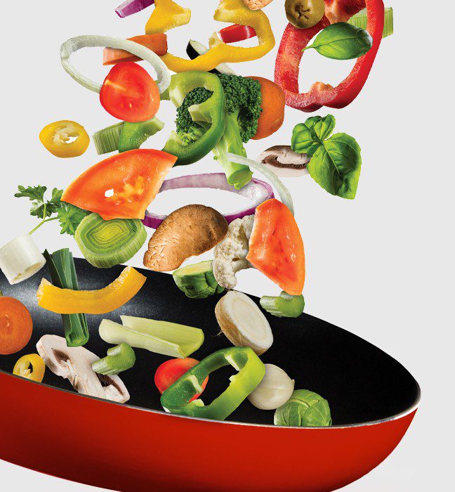 Close up photograph of a T-fal pan cooking a vegetable wok.
