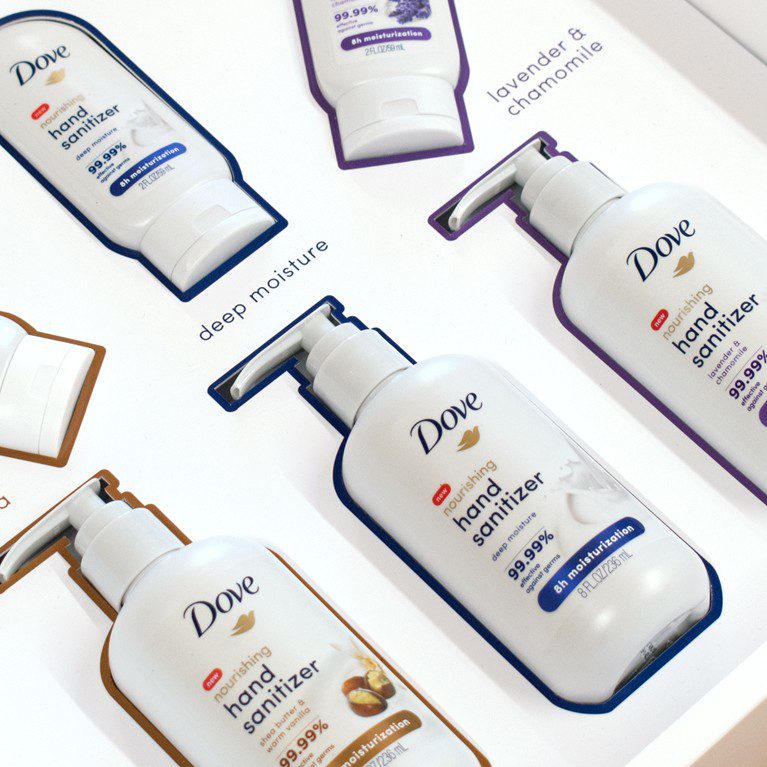 Close-up shot of the inside of an unboxing experience sales kit promoting skin moisturizing Dove hand sanitizer.