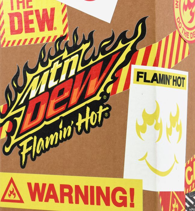 Close-up shot of a unique corrugate shipper outfitted with the brands iconic logos, phrases and mascot created for the influencer unboxing experience kits promoting the limited edition flavor FLAMIN HOT Mountain Dew.