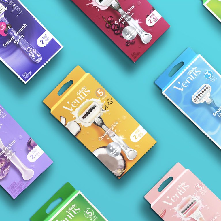 Photograph of a full product line of Gillette Venus including smooth, comfortglide and deluxe smooth razors and cartridges, showcasing brand identity design services for consumer packaged goods.