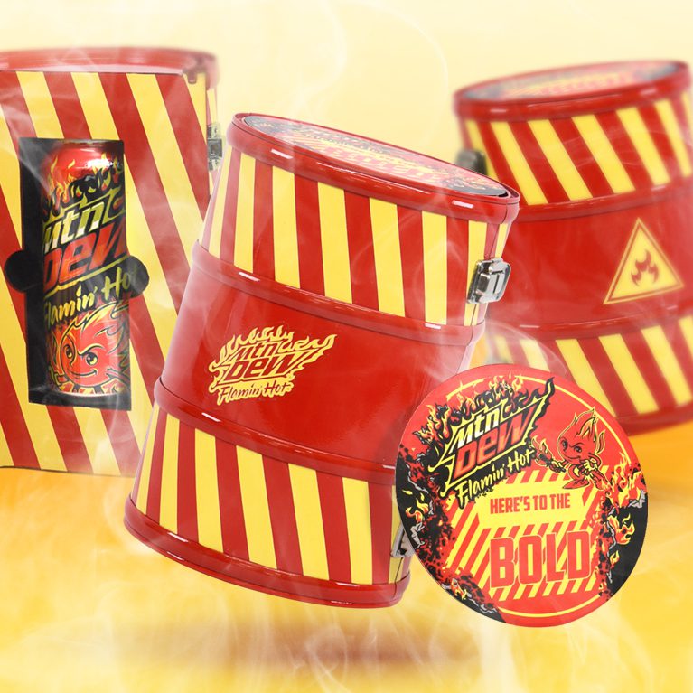 Photograph of three ‘fire retardant’ case themed influencer unboxing experience kits promoting the limited edition flavor FLAMIN HOT Mountain Dew, featuring a custom headband and note.