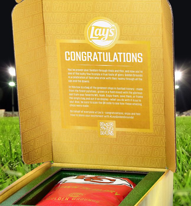 Photograph of a consumer sweepstake prize box for Lays Golden Ground, opening up to reveal limited edition packaging themed around an NFL team inside.