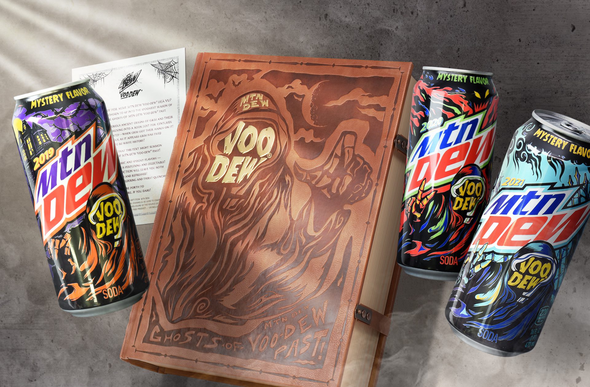 Photograph of a halloween themed influencer unboxing experience for Mountain Dew Voodew, featuring three cans of limited edition mtn dew flavors.