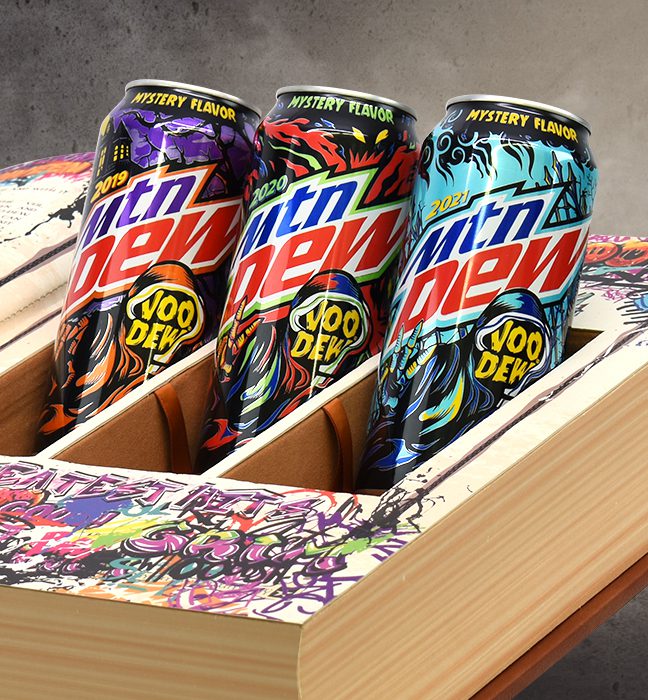 Photograph of the inside of a halloween themed influencer unboxing experience for Mountain Dew Voodew, featuring three cans of limited edition mtn dew flavors.